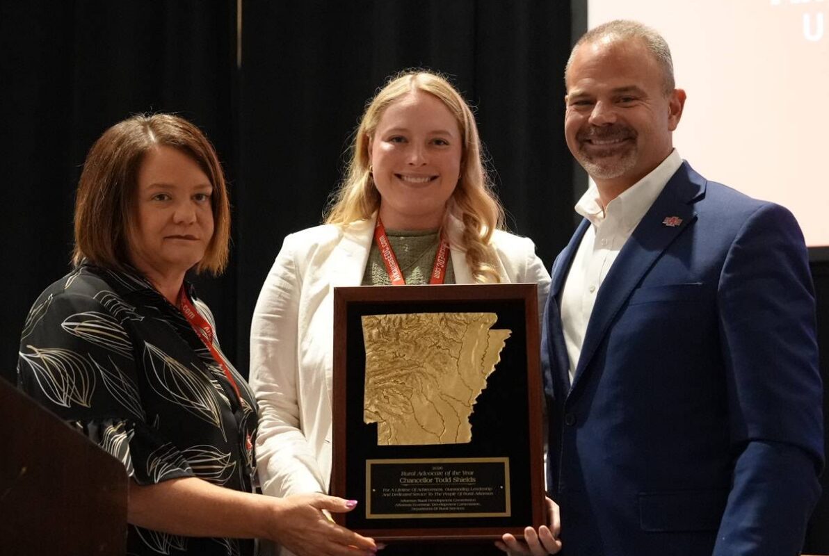 A-State Chancellor Todd Shields stands with two women representing the Arkansas Rural Development Commission while receiving Rural Advocate of the Year Award.