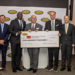 Pictured in front of Hytrol backdrop are CREST Center and Hytrol Conveyor Company representatives (from left): Jerry Morgan, Dr. Robin Myers, Dr. Calvin White, Ike Wheeler, Robert Jones, Phillip Poston, David Peacock and Ruth Poston.